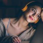 Une femme regarde une vidéo sur son ordinateur portable.