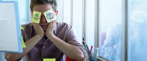 Un employé de bureau avec des post-it collés sur les yeux