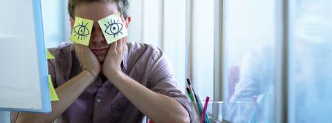 Étude : le présentéisme en France Un employé de bureau avec des post-it collés sur les yeux