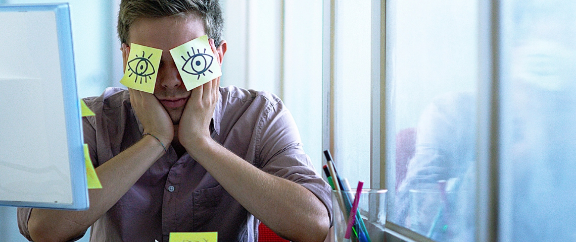 Étude : le présentéisme en France Un employé de bureau avec des post-it collés sur les yeux