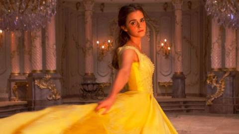 Une princesse disney en robe jaune regarde la caméra