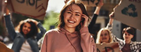 Patagonia lance un site de rencontre activiste Une jeune femme avec un sweat rose dans une manifestation