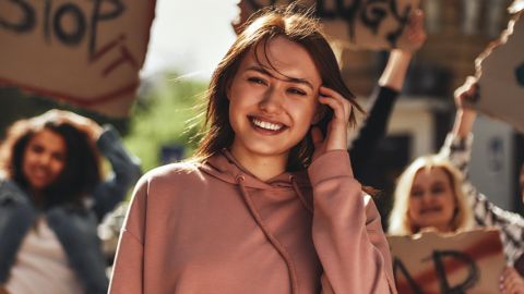 Patagonia lance un site de rencontre activiste Une jeune femme avec un sweat rose dans une manifestation