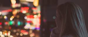 Une jeune femme regardant la ville illuminée