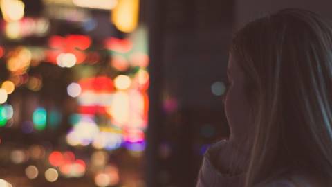 Une jeune femme regardant la ville illuminée