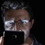 Homme regardant son smartphone de nuit