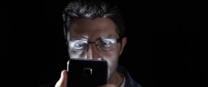 Homme regardant son smartphone de nuit