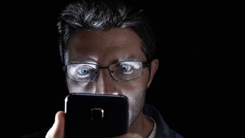 Homme regardant son smartphone de nuit