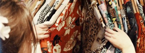 vêtements-seconde-main Une personne fouille dans un dressing
