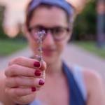 Une femme tenant une fleur entre ses doigts