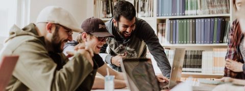 Employee-advocacy-experience-ambassadeur Des employés rient devant un ordinateur