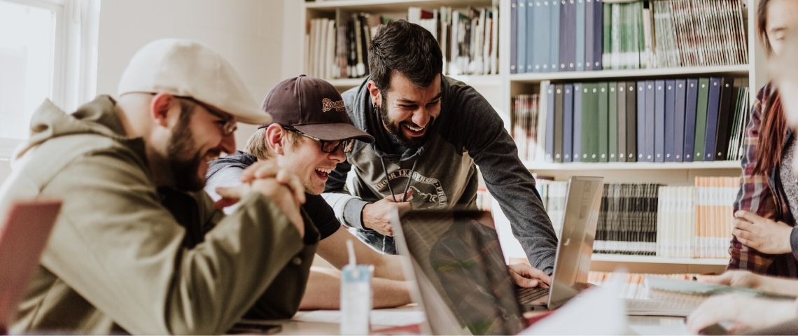 Employee-advocacy-experience-ambassadeur Des employés rient devant un ordinateur