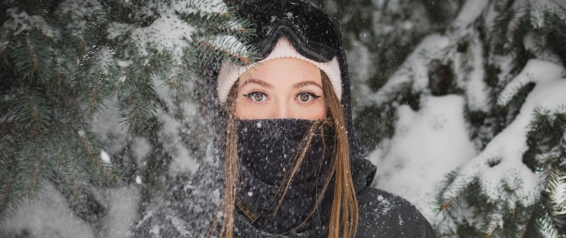 Marketing-saisonnier-chaque-saison-besoins Une jeune femme porte un bonnet et une tenue de ski dans la neige