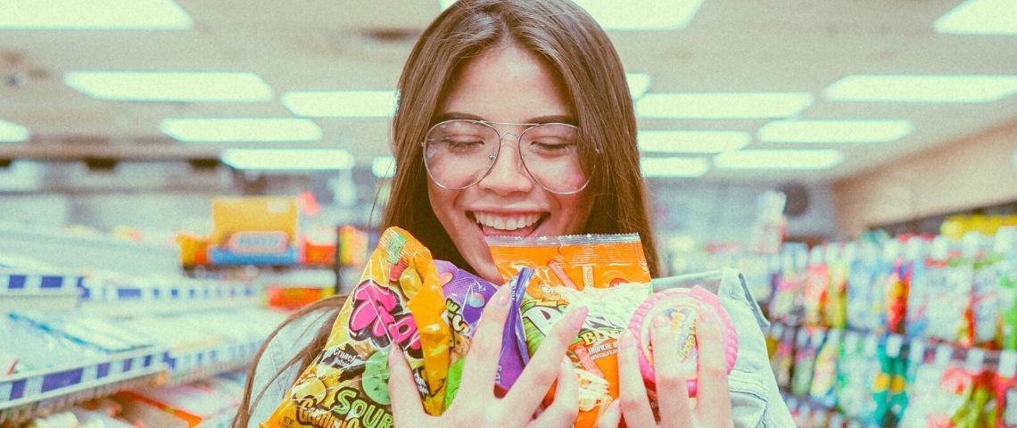 Comment choisir le bon prix ? Une jeune femme tiens des bonbons dans sa main