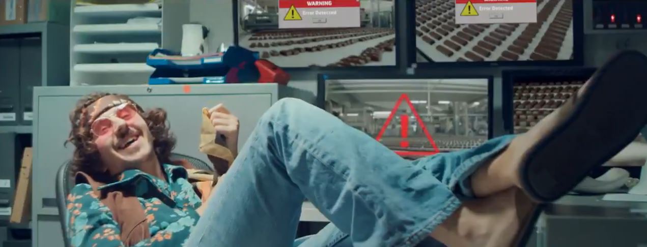 Snickersgate-canular-bounty-la verite devoilee Capture d'écran de la vidéo : un technicien en mode hippie, les pieds sur son bureau