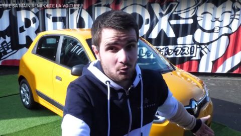 une jeune youtubeur devant une voiture jaune qui présente une vidéo de divertissement publicitaire