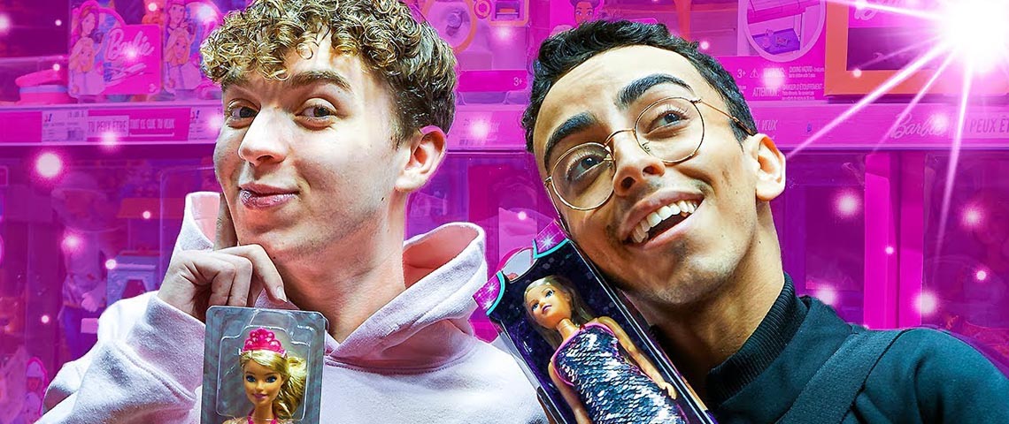 Les star d'Instagram deux jeune hommes qui tiennent des poupées Barbie sur un fond rose.