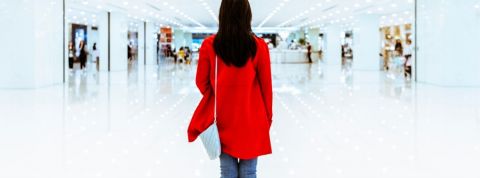 5 initiatives pour une meilleure inclusion des personnes autistes Une femme avec un manteau rouge de dos dans un centre commercial