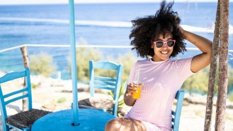 Une femme seule et heureuse qui boit un jus d'orange