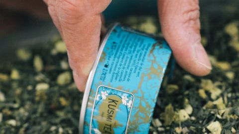 Une main remplit une boîte de Kusmi Tea