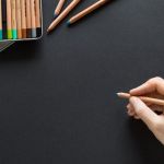 une main avec un crayon de couleur