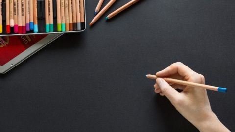 une main avec un crayon de couleur