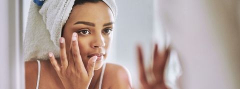 La beauté « au naturel » coûte cher à l'industrie des cosmétiques Une femme qui se prépare devant le miroir