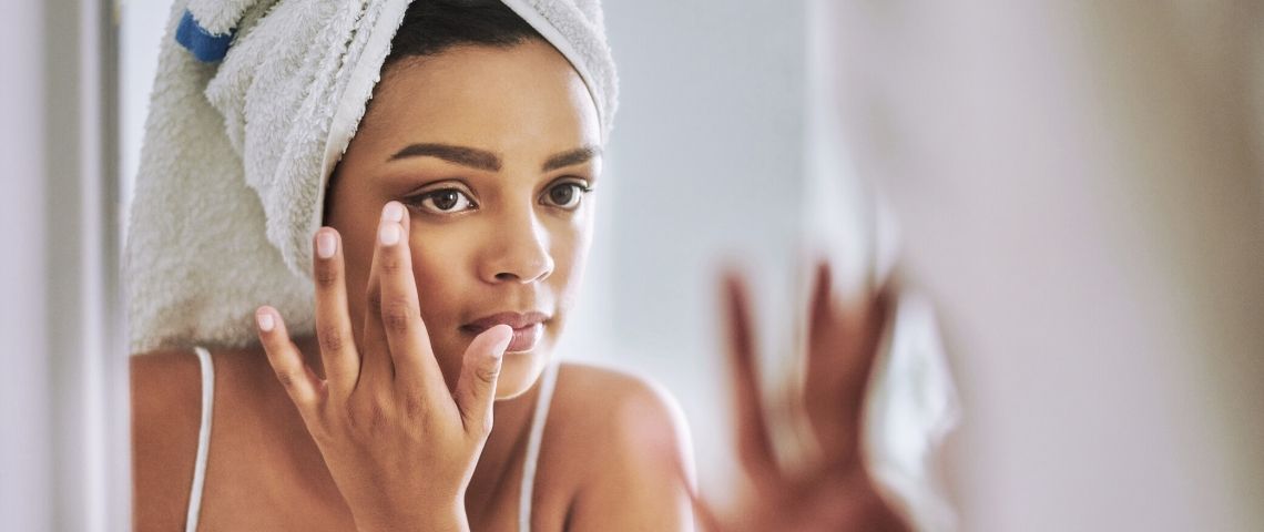 La beauté « au naturel » coûte cher à l'industrie des cosmétiques Une femme qui se prépare devant le miroir