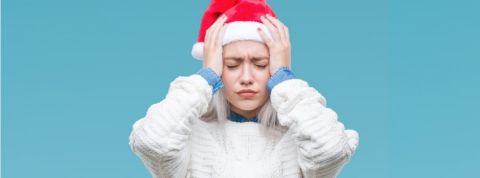 Les jeunes actifs ne veulent plus fêter Noël au bureau Une jeune femme avec un bonnet de père Noël qui a la migraine