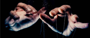 Des mains d'hommes en train de manipuler des ficelles de pantin