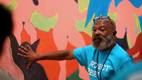 un homme décrit une oeuvre dans un musée