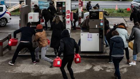 des personnes courent avec des bidons d'essence