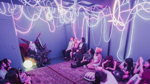 Des gens assis dans une salle avec des néons au plafond