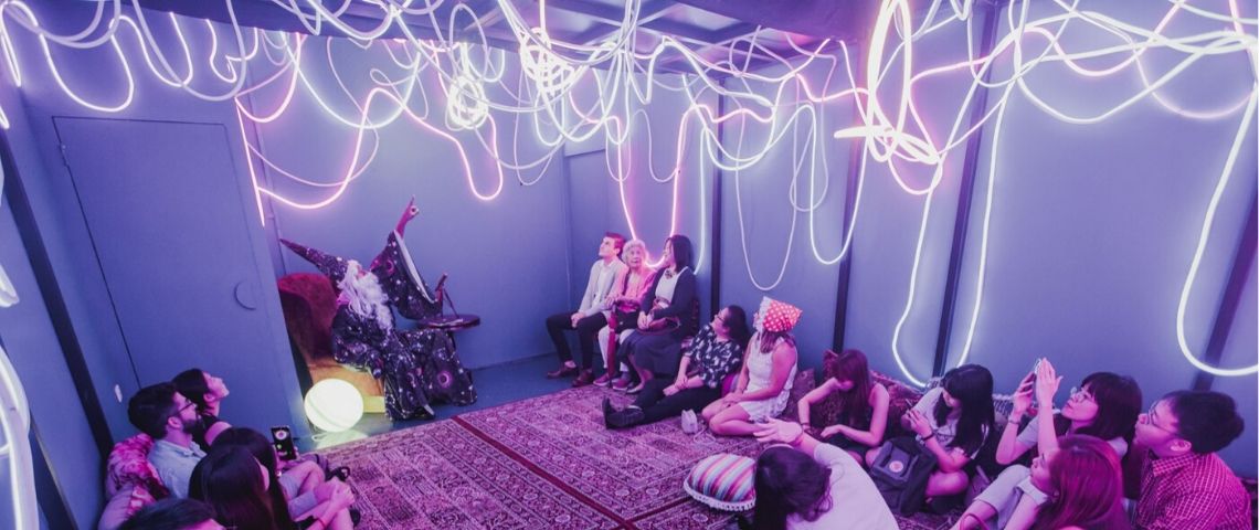 Découvrez 3 concepts de restaurants immersifs Des gens assis dans une salle avec des néons au plafond