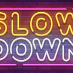Un néon portant l'inscription Slow Down