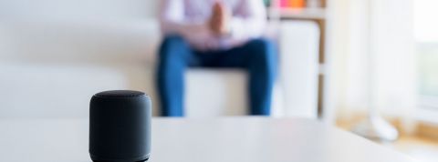 Ces assistants vocaux qui en savent plus sur vous que… vous Homme assis sur son canapé et parle à son assistant vocal