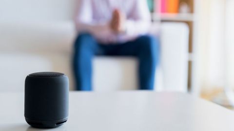 Ces assistants vocaux qui en savent plus sur vous que… vous Homme assis sur son canapé et parle à son assistant vocal
