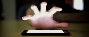 Une main cherche à s'emparer de son smartphone