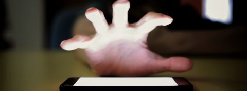 On a testé : abandonner notre application préféré pendant une semaine Une main cherche à s'emparer de son smartphone