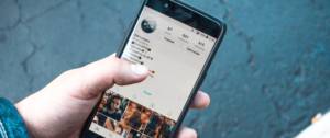 Personne tenant un smartphone danas sa main et navigue sur l'application Instagram