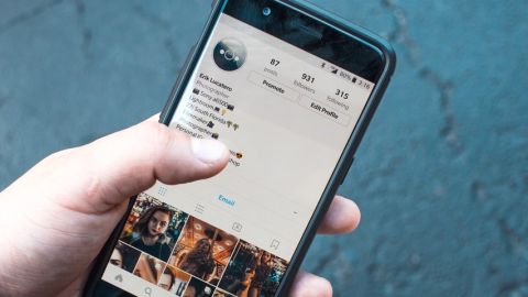 Personne tenant un smartphone danas sa main et navigue sur l'application Instagram