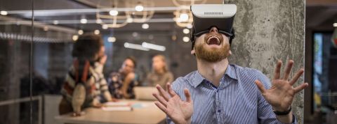 Petit lexique satirique des mots de la tech Salarié d'une start-up portant un casque de réalité virtuelle avec un air ébahi