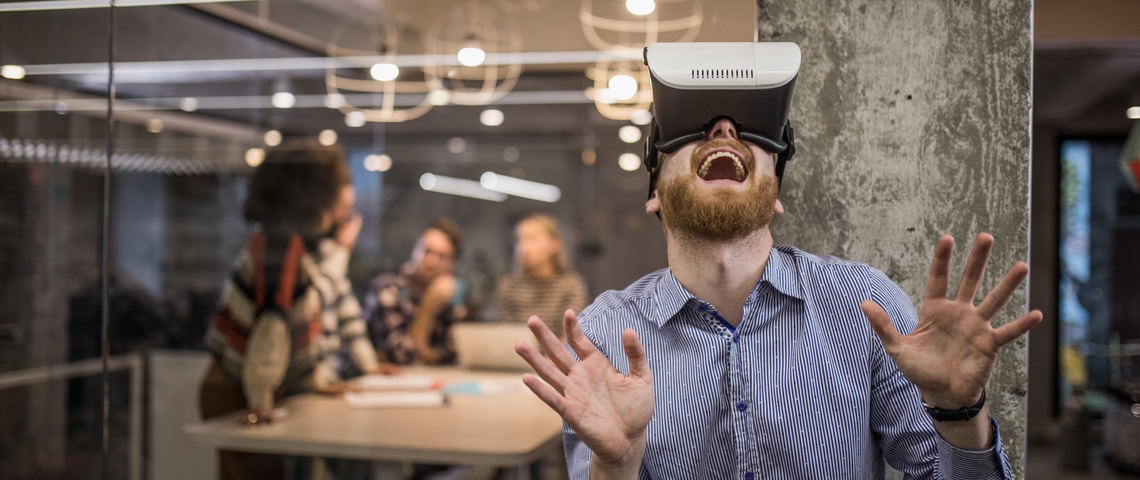 Petit lexique satirique des mots de la tech Salarié d'une start-up portant un casque de réalité virtuelle avec un air ébahi