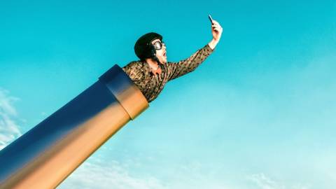 Un homme tenant son mobile dans un canon