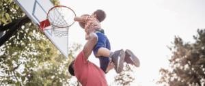 Papa porte son petit garçon qui joue au basket