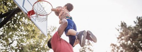 Impact : ce n’est pas la taille qui compte Papa porte son petit garçon qui joue au basket