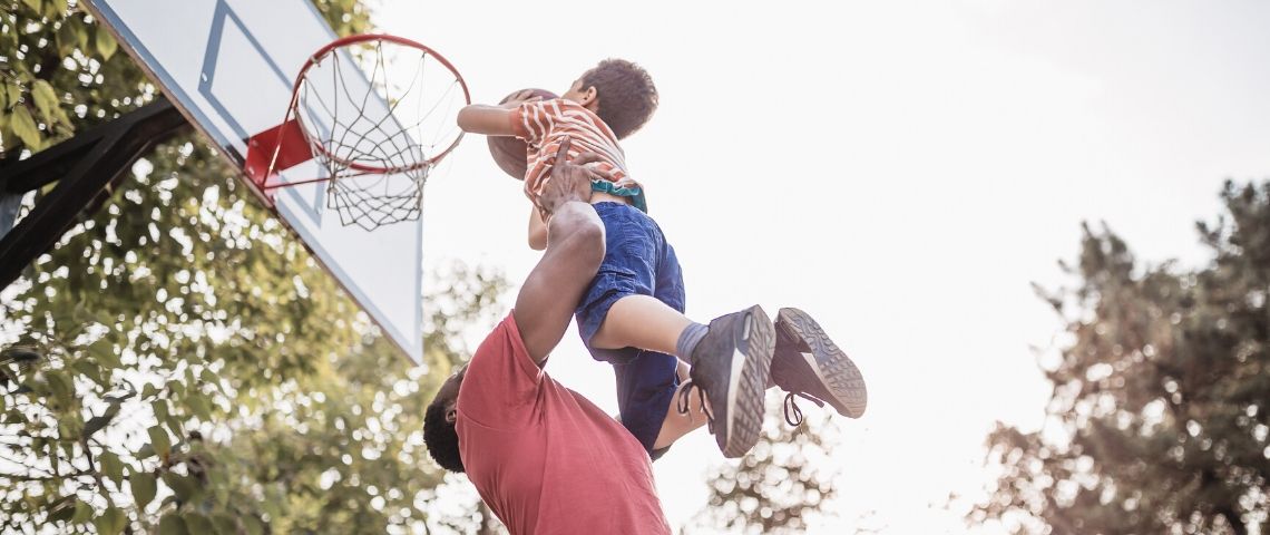Impact : ce n’est pas la taille qui compte Papa porte son petit garçon qui joue au basket