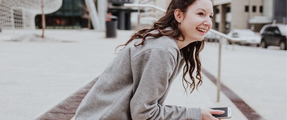 Créer une app intuitive, en accord avec les besoins clients Une femme tient un smartphone entre ses mains
