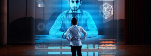5 tech qui promettent d'améliorer le télétravail Homme devant hologramme géant de son collègue pendant une visio-conférence