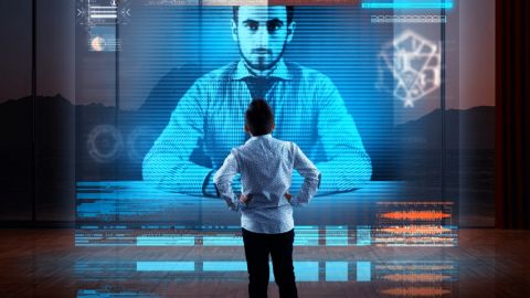 5 tech qui promettent d'améliorer le télétravail Homme devant hologramme géant de son collègue pendant une visio-conférence